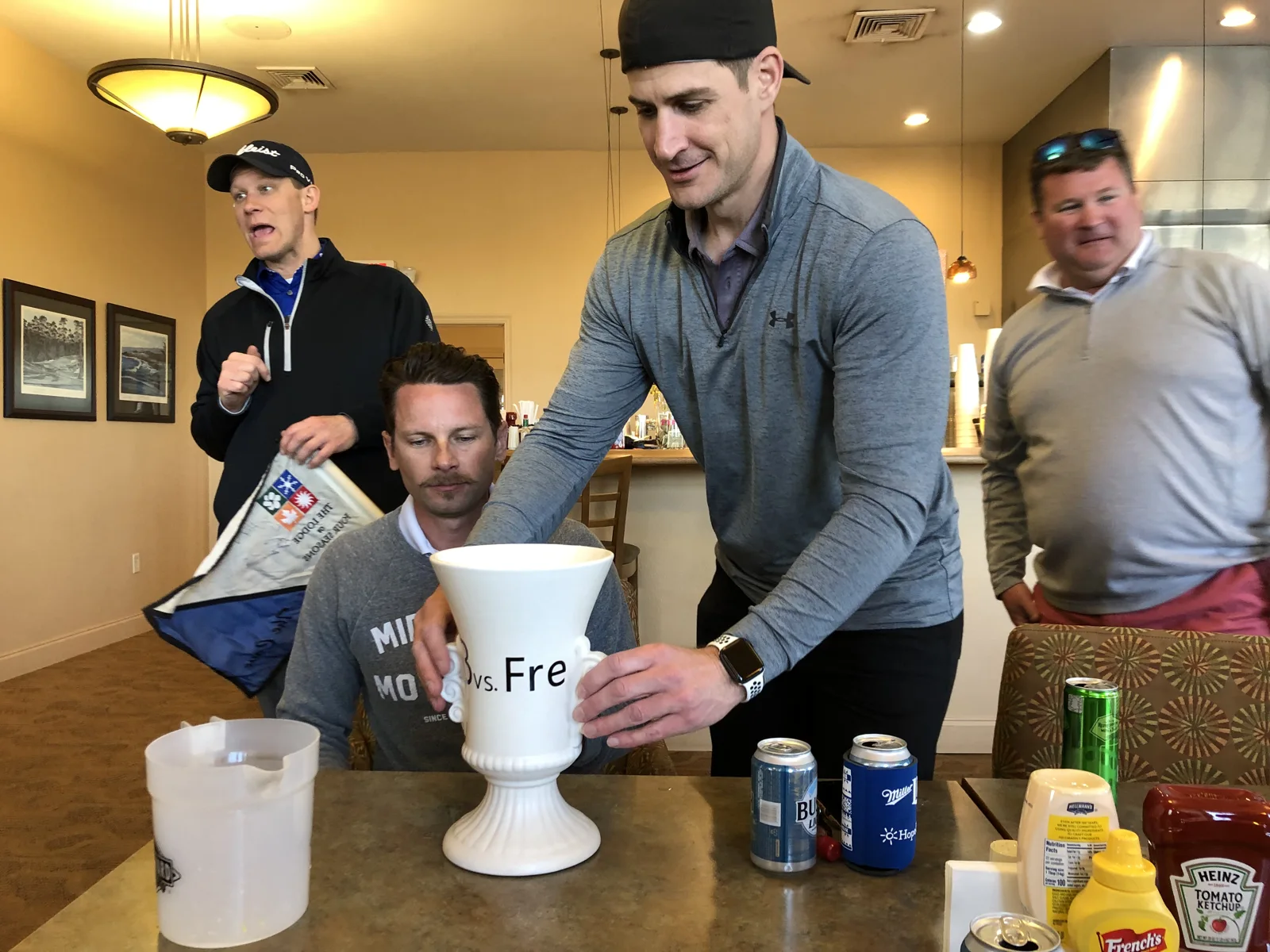 Friends standing and sitting around the trophy