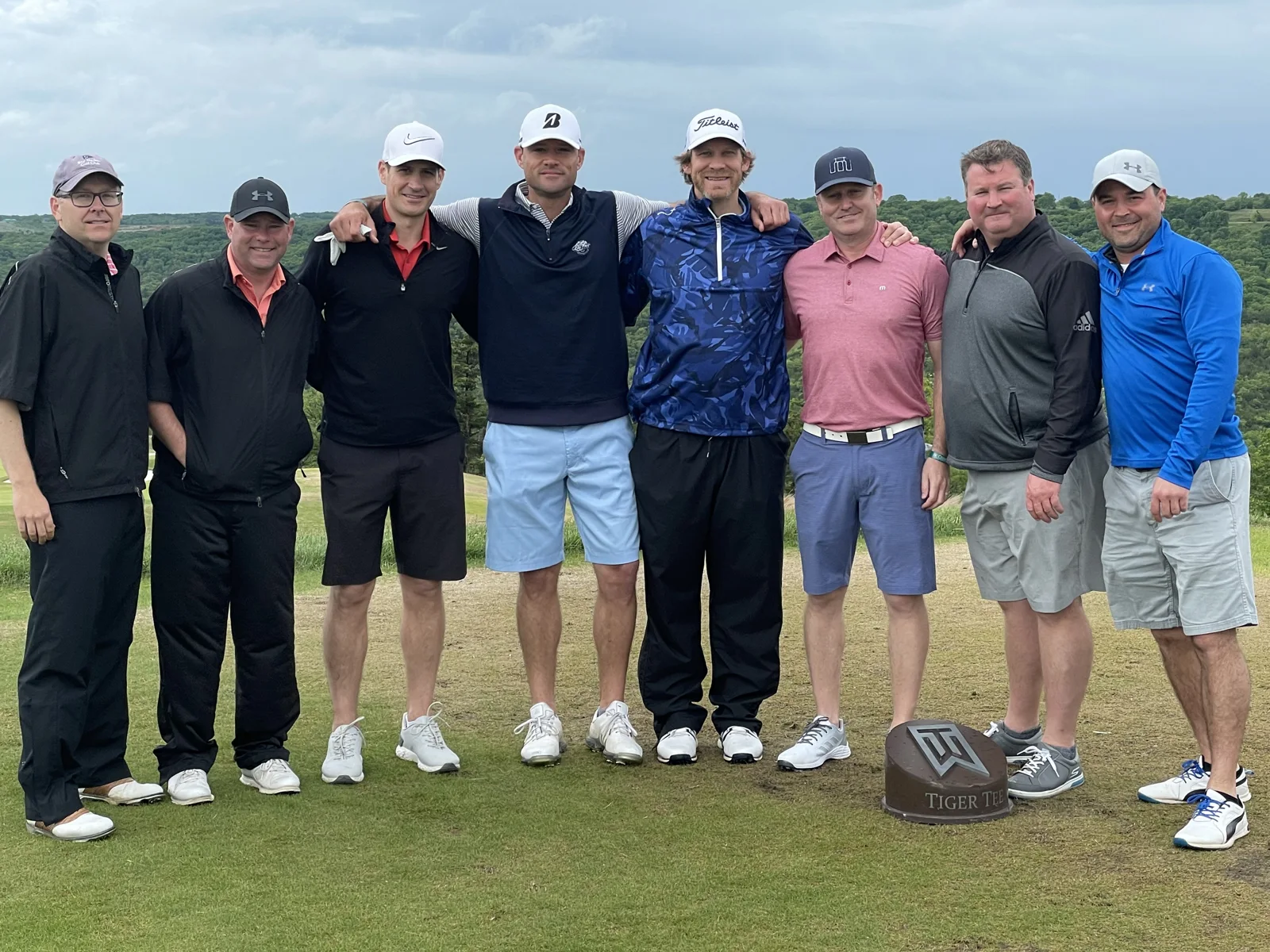 A large group of friends lined up on the golf course