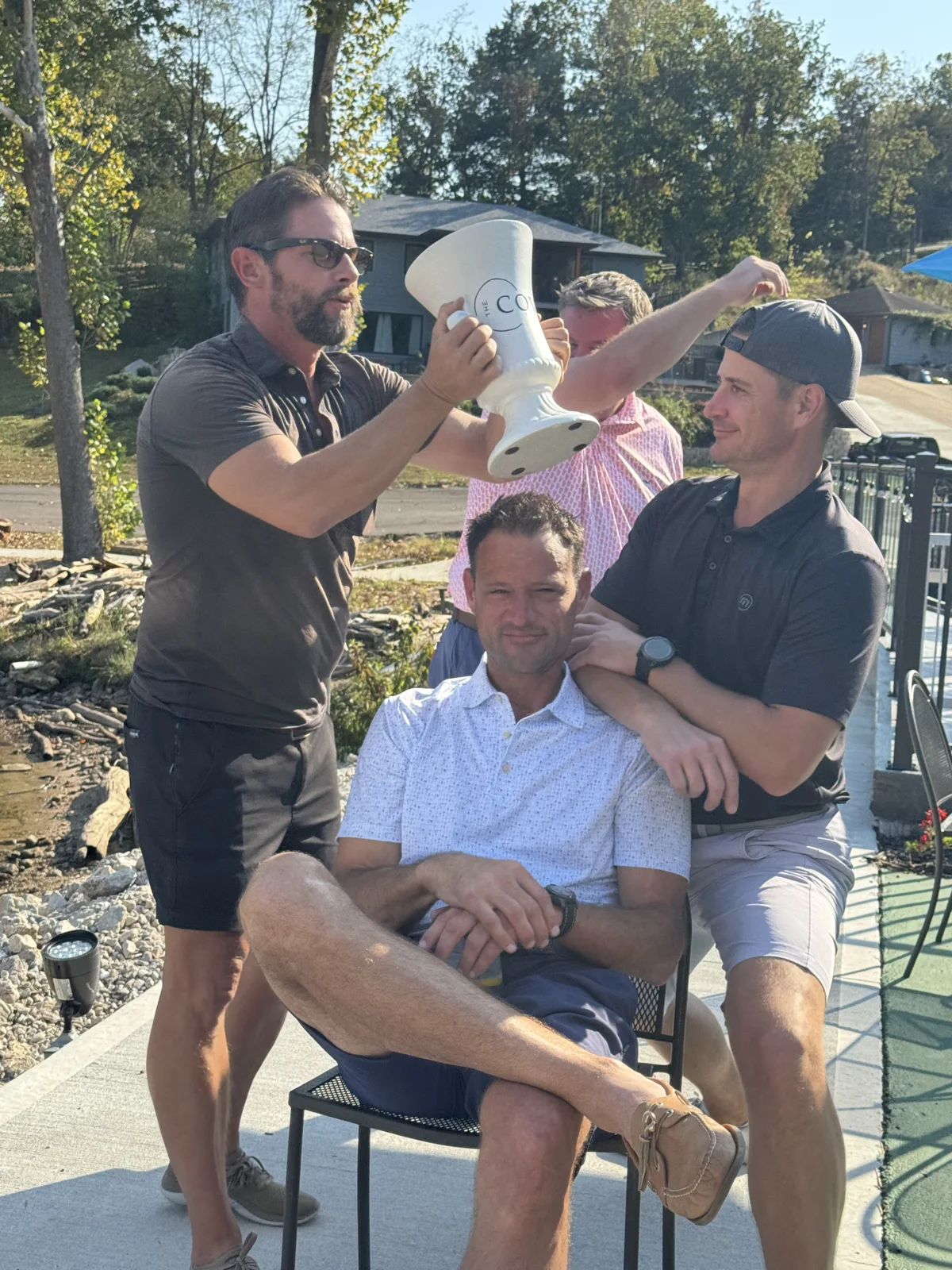 Friends posing together with the trophy outdoors
